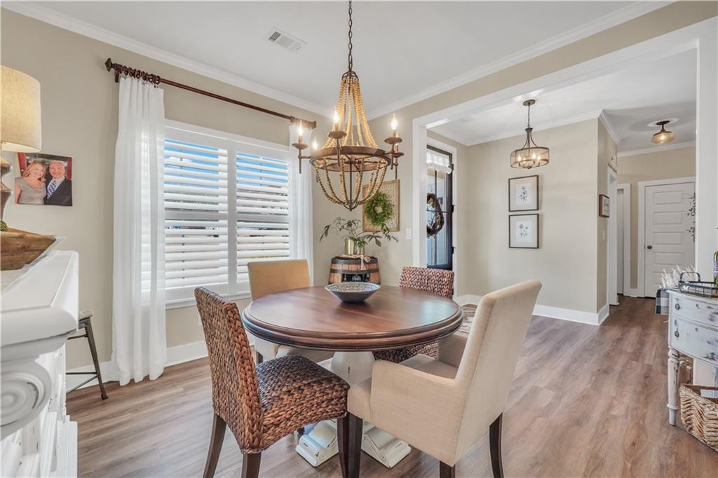 230 Alcovy Reserve Way Covington, GA 30014 - Photo 13 of 53 a dining room with furniture a chandelier and wooden floor