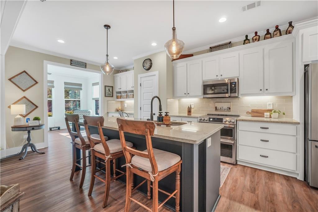 230 Alcovy Reserve Way Covington, GA 30014 - Photo 26 of 53 a kitchen with kitchen island granite countertop a sink counter and chairs