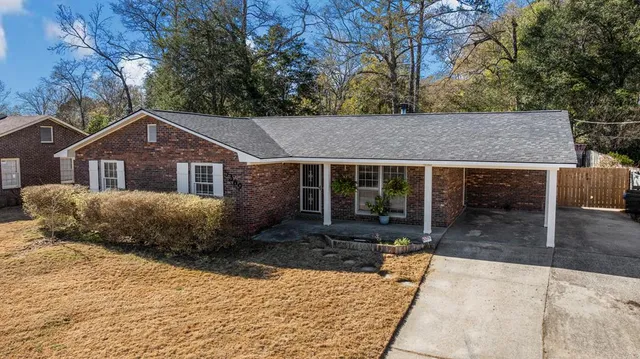 a front view of a house with a yard and trees