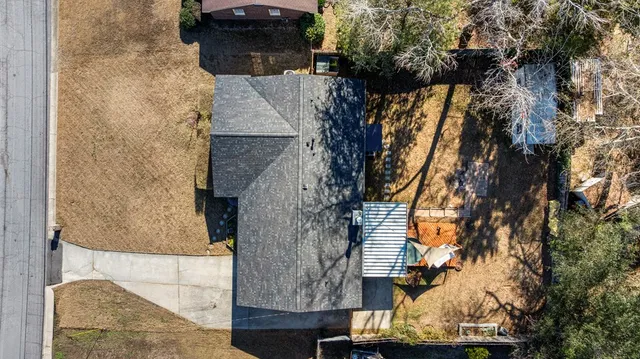 an aerial view of a house with large trees