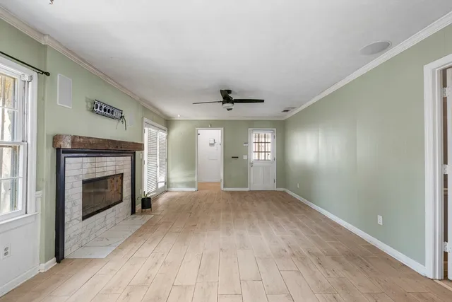 a view of empty room with a fireplace and windows