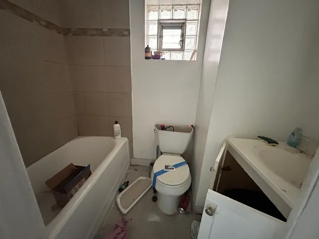 a white toilet sitting next to a bathroom sink and tub