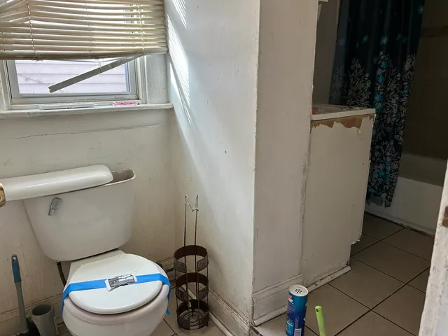 a white toilet sitting next to a window