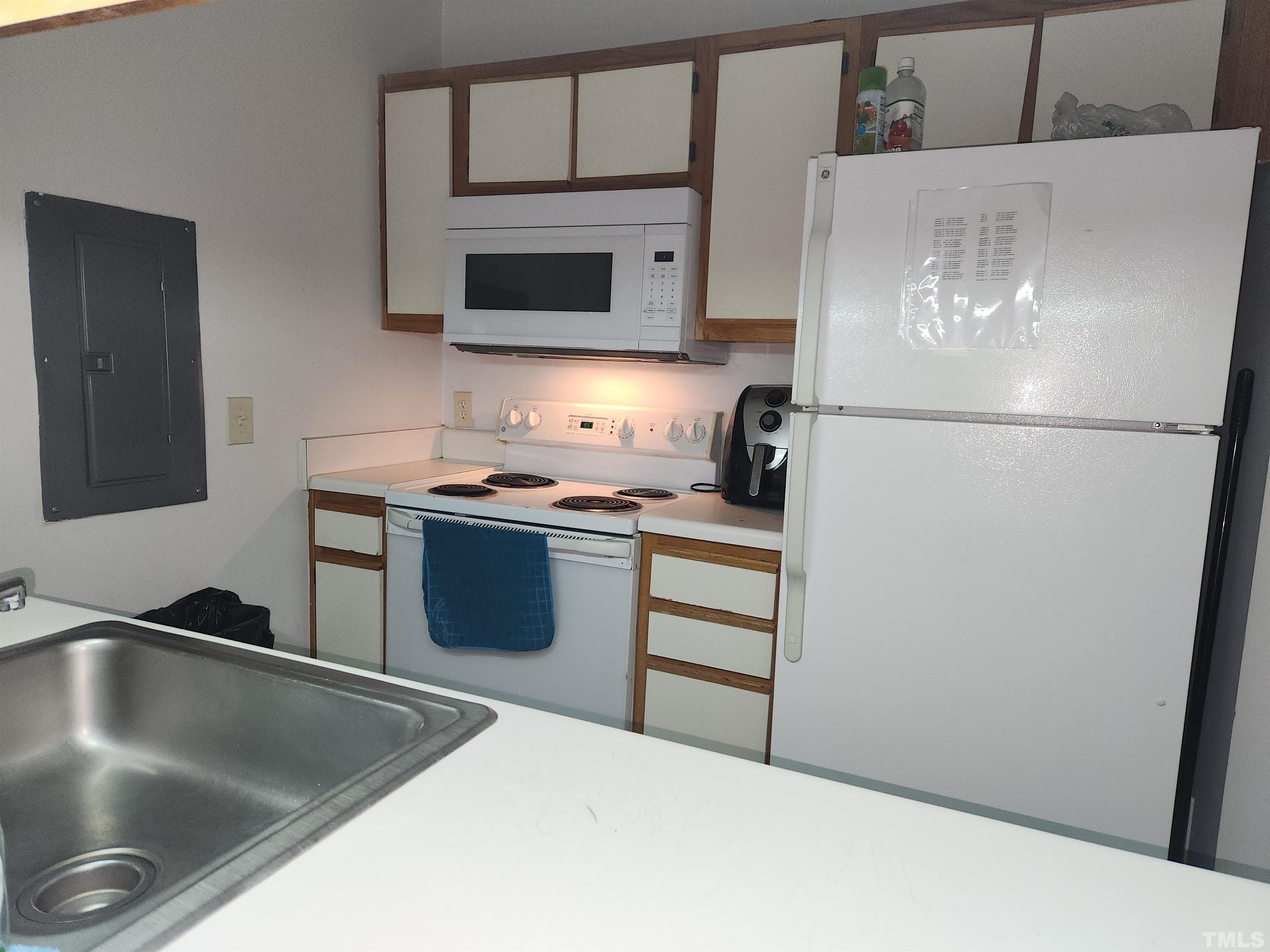 1440 Collegiate Circle, Unit 103 Raleigh, NC 27606 - Photo 6 of 10 a kitchen with stainless steel appliances a refrigerator a stove a microwave and a sink