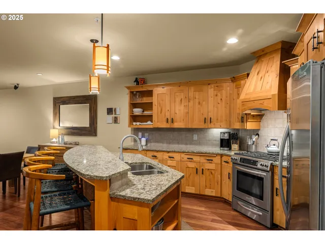 a kitchen with stainless steel appliances granite countertop a sink stove and refrigerator