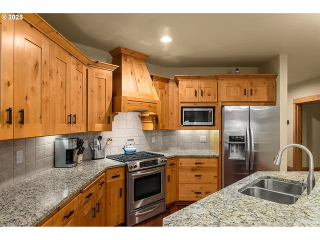 a kitchen with stainless steel appliances granite countertop a stove a sink and a microwave