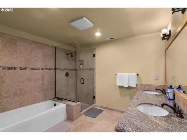a bathroom with a granite countertop sink a mirror and shower