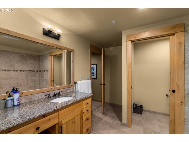 a bathroom with a granite countertop sink a mirror and shower