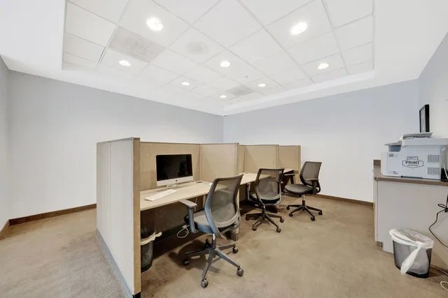 a view of a workspace with furniture and a window