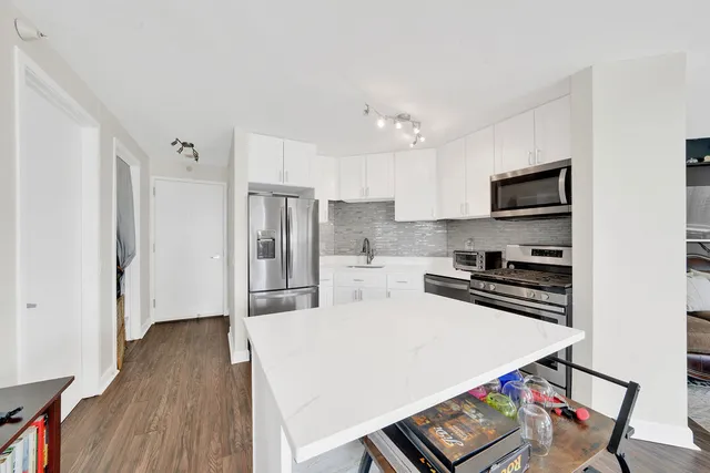 a kitchen with stainless steel appliances a refrigerator and a stove top oven