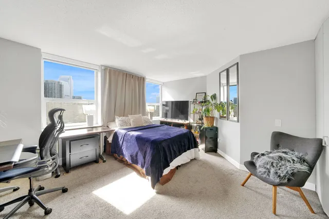 a spacious bedroom with a bed and a chair