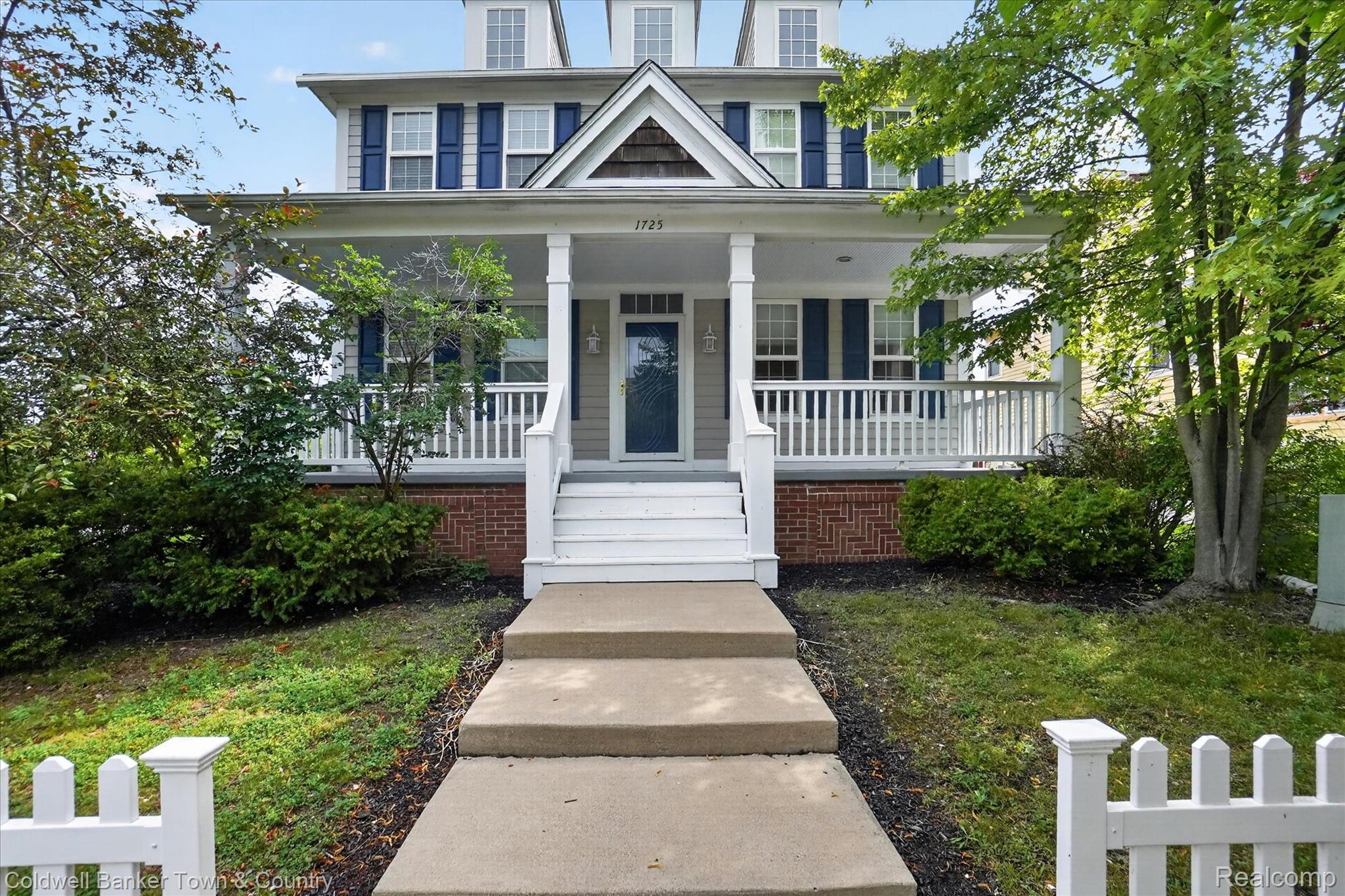 1725 Town Commons Drive Howell, MI 48855 - Photo 4 of 53 Traditional facade featuring a full-width covered porch, dormer windows, and blue window shutters