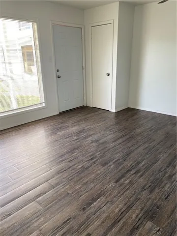 a view of a room with wooden floor and window