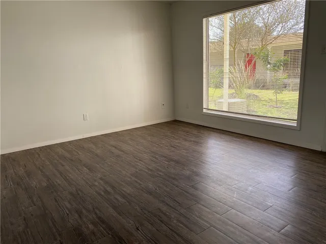an empty room with wooden floor and a window