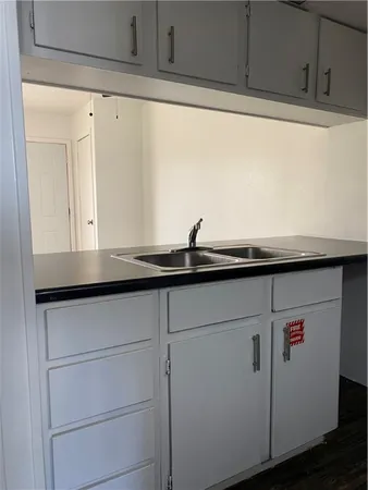 a close view of kitchen sink and dishwasher with wooden floor