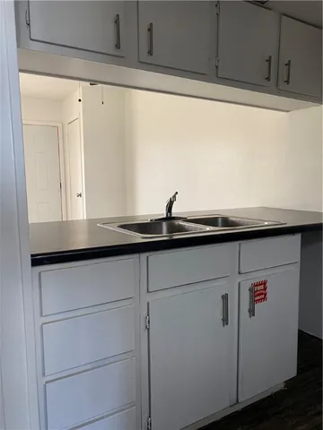 a close view of kitchen sink and dishwasher with wooden floor