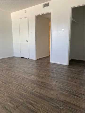 a view of an empty room with wooden floor