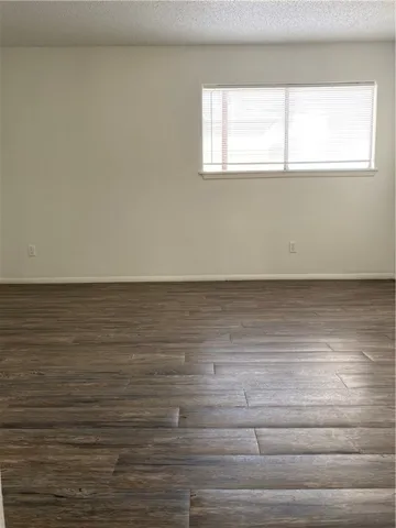 a view of a room with wooden floor and window