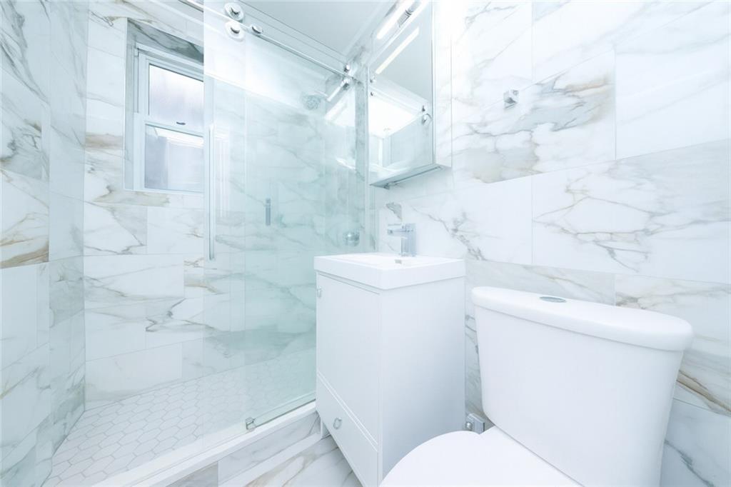 6801 Shore Road, Unit 2T Brooklyn, NY 11220 - Photo 12 of 20 a bathroom with a sink toilet and shower