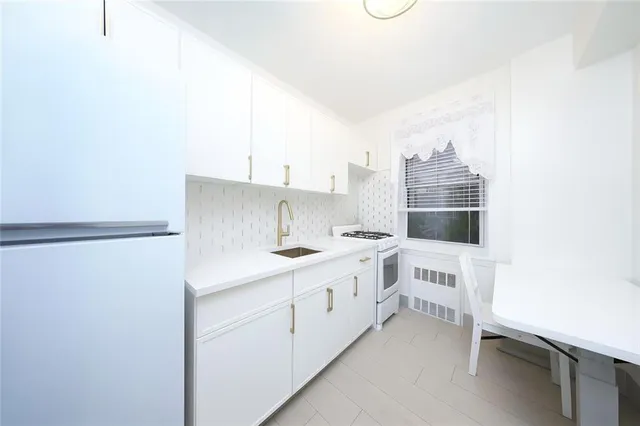a kitchen with white cabinets and white appliances