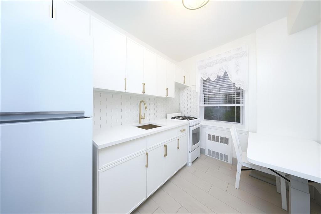6801 Shore Road, Unit 2T Brooklyn, NY 11220 - Photo 9 of 20 a kitchen with white cabinets and white appliances