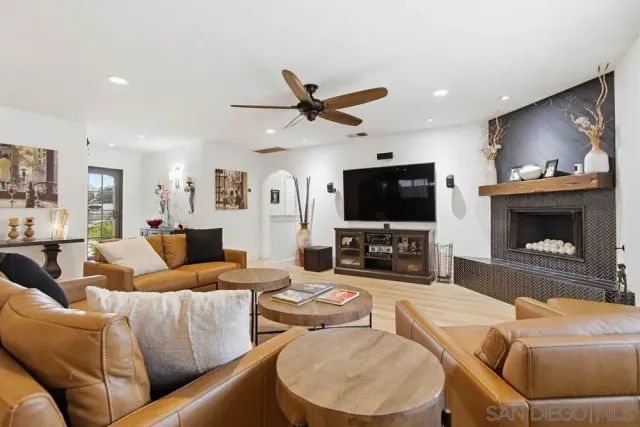 a living room with furniture and a view of kitchen