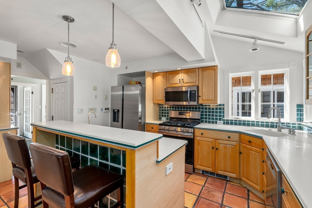 80 Fenwick Road Newton, MA 02468 - Photo 9 of 35 a kitchen with stainless steel appliances granite countertop a stove a sink dishwasher a dining table and chairs with wooden floor