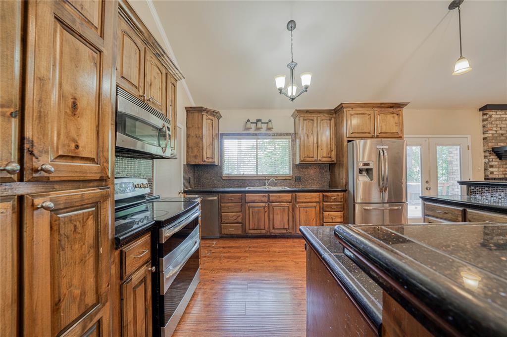 1006 Rikkity Lane Mount Pleasant, TX 75455 - Photo 11 of 39 a kitchen with stainless steel appliances granite countertop a refrigerator and a stove top oven