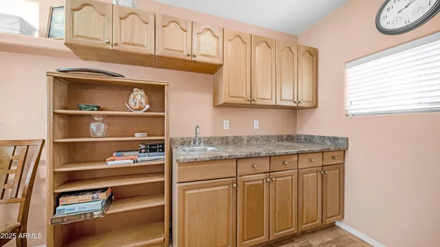a kitchen with granite countertop a stove and a white cabinets