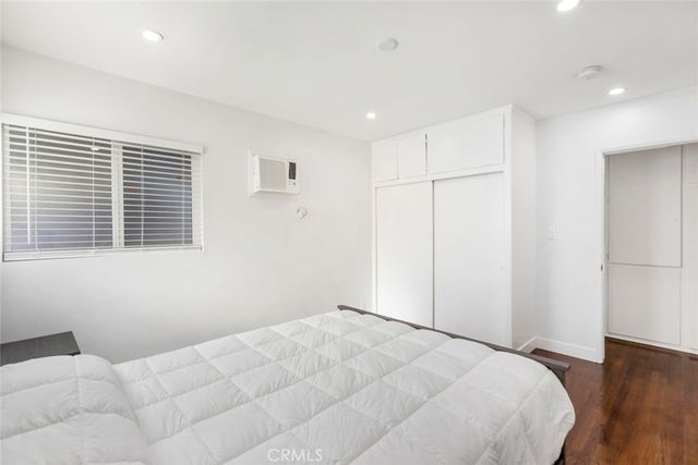 a view of a room with a bed and wooden floor