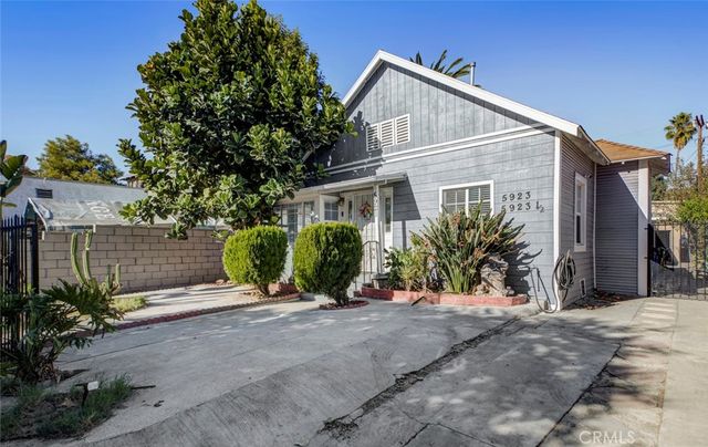 a view of a house with a small yard and potted plants