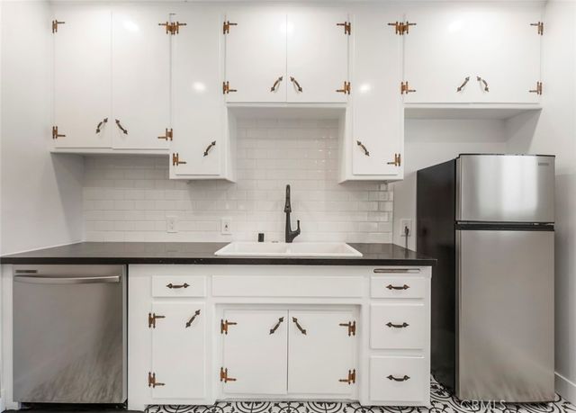 a kitchen with stainless steel appliances granite countertop a sink and a refrigerator