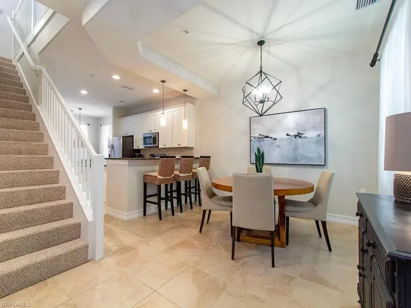 a view of a dining room and livingroom with furniture wooden floor a chandelier