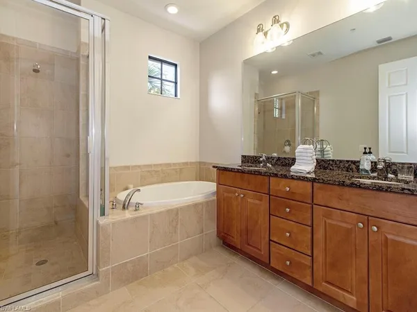 a spacious bathroom with a tub sink shower and mirror