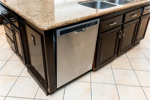 a kitchen with granite countertop a refrigerator and a sink