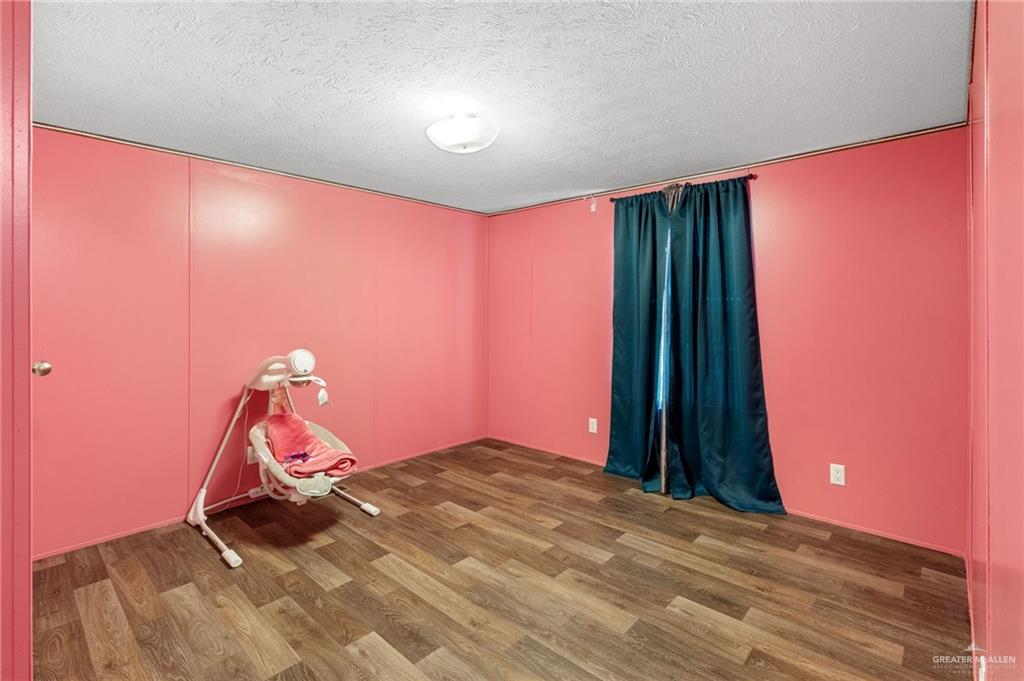 1415 Spear Street Weslaco, TX 78596 - Photo 11 of 14 a bedroom with a bed and a chandelier