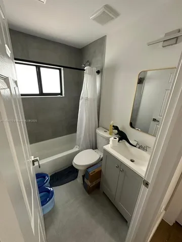 a white toilet sitting next to a bathroom sink and a shower