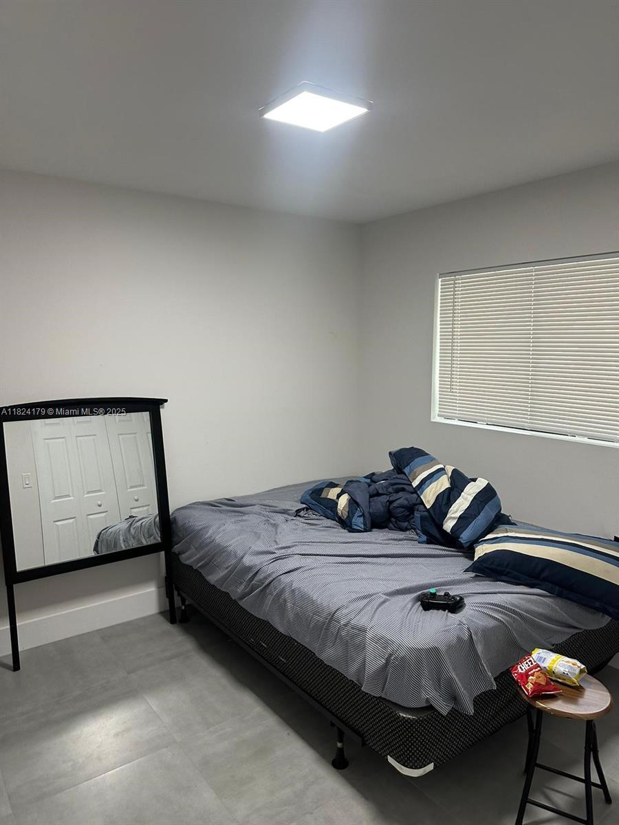 147 Northwest 61st Street Miami, FL 33127 - Photo 10 of 17 a bedroom with a bed and window