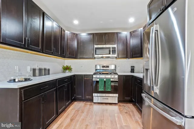 a kitchen with kitchen island granite countertop a sink cabinets and wooden floor