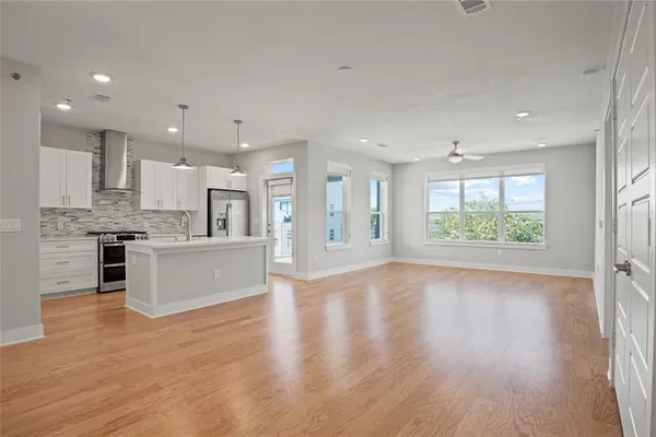 a large kitchen with stainless steel appliances granite countertop a lot of counter space and wooden floor