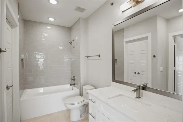 a bathroom with a sink a toilet a mirror and shower