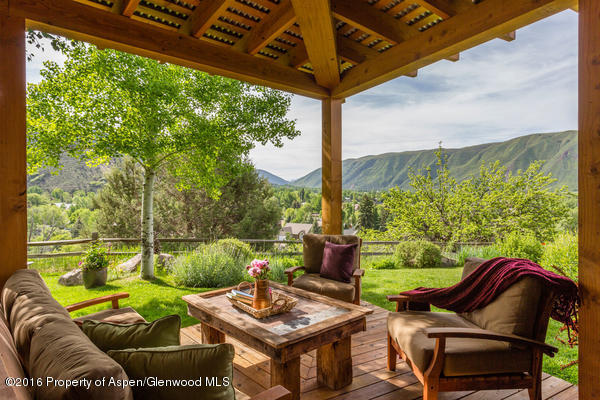 216 Curtis Lane Basalt, CO 81621 - Photo 3 of 32 a view of a patio with couches chairs dining table and chairs under an umbrella