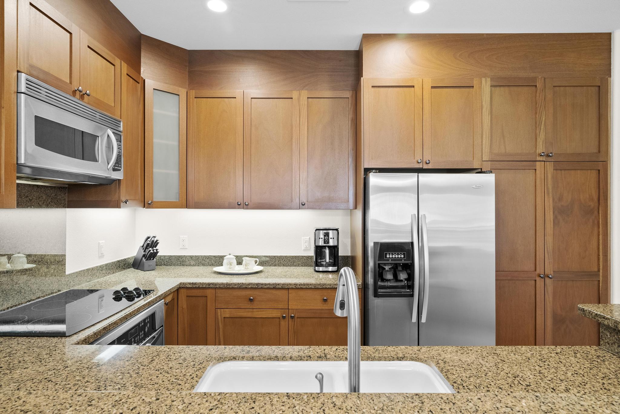 69-1033 Nawahine Place, Unit 18D Waikoloa, HI 96738 - Photo 6 of 25 a kitchen with granite countertop a refrigerator and a sink
