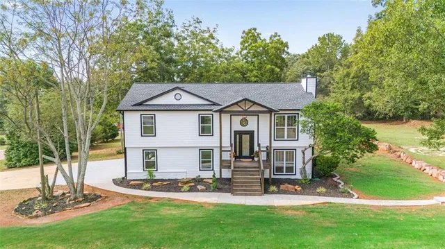 a front view of a house with a yard garden and outdoor seating