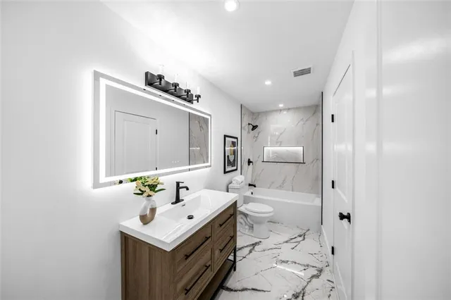 a bathroom with a sink a mirror and toilet