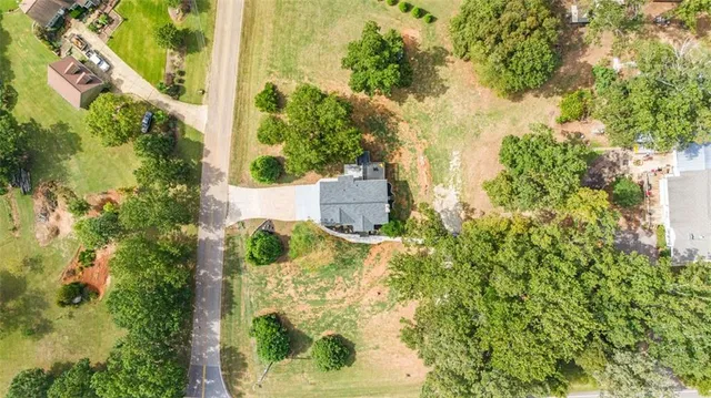 an aerial view of residential houses with outdoor space and trees