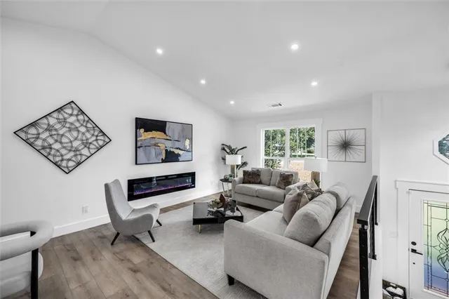 a living room with furniture wooden floor and a flat screen tv