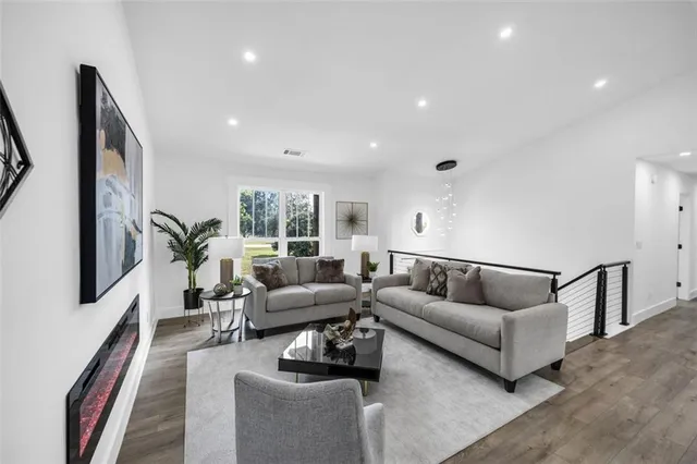 a living room with furniture kitchen view and a large window