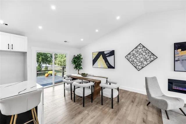 a living room with stainless steel appliances kitchen island granite countertop a stove and a sink