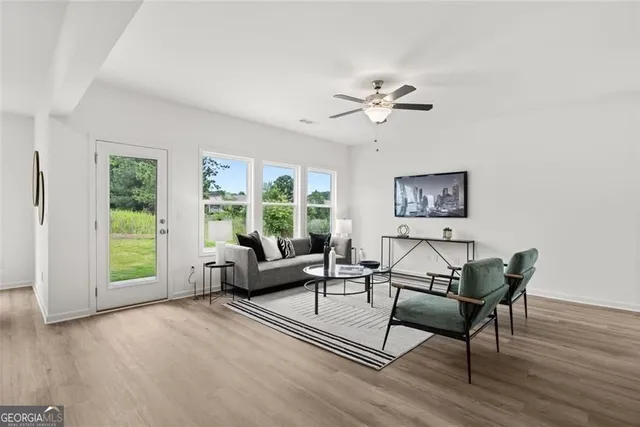 a kitchen with stainless steel appliances kitchen island granite countertop a dining table chairs and view living room